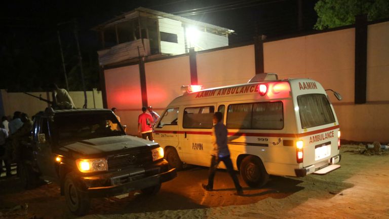 A man walks past an ambulance and armed security forces at the scene of an attack outside an hotel in Mogadishu, Somalia June 14, 2017
