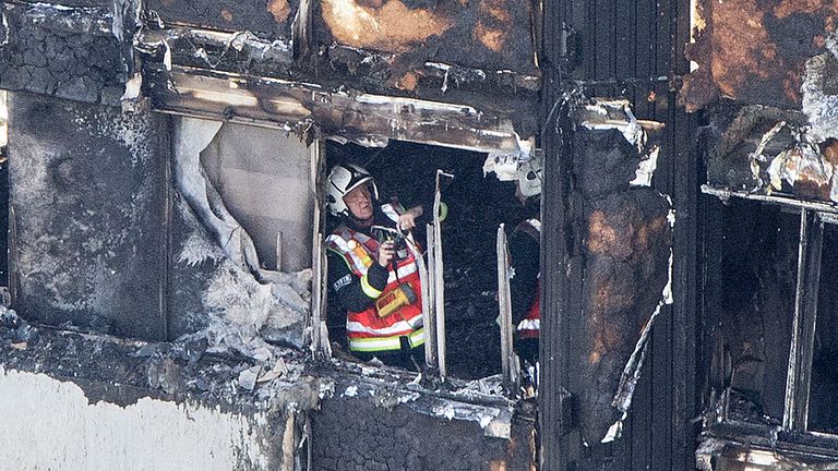 A firefighter investigates a floor after a fire engulfed the 24-storey Grenfell Tower 