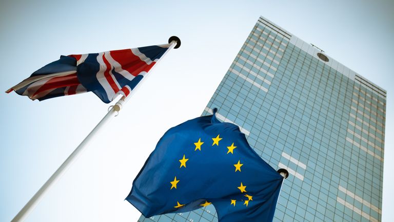 The UK and EU flags are hung on poles outside the European Parliament in Brussels