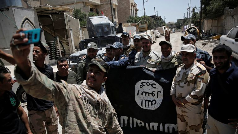 Iraqi troops with a captured Islamic State flag