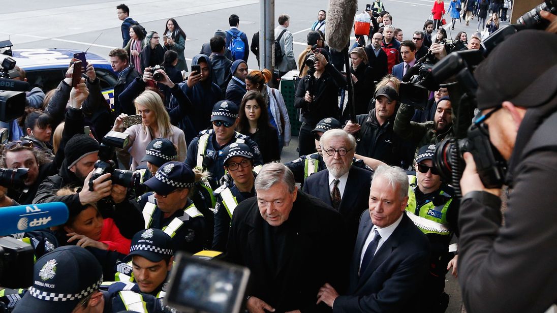 Cardinal George Pell walks with a heavy Police guard to the Melbourne Magistrates' Court on July 26, 2017 in Melbourne, Australia