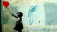Girl holding a heart balloon. Photograph of Banksy&#39;s graffiti street art from 2004. Pic: Oliver Grove / PYMCA /REX/Shutterstock