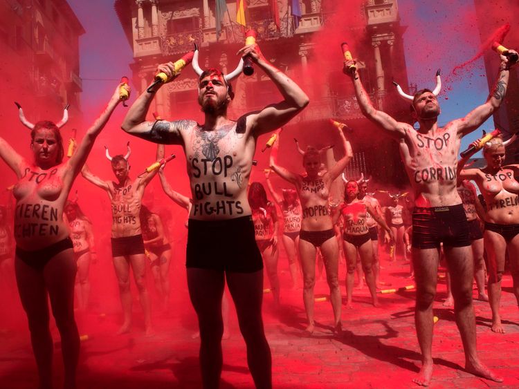 Pro-animal rights activists spread red powder on themselves as they break fake "banderillas" (spears to jab the bull) to protest against bullfighting in Pamplona