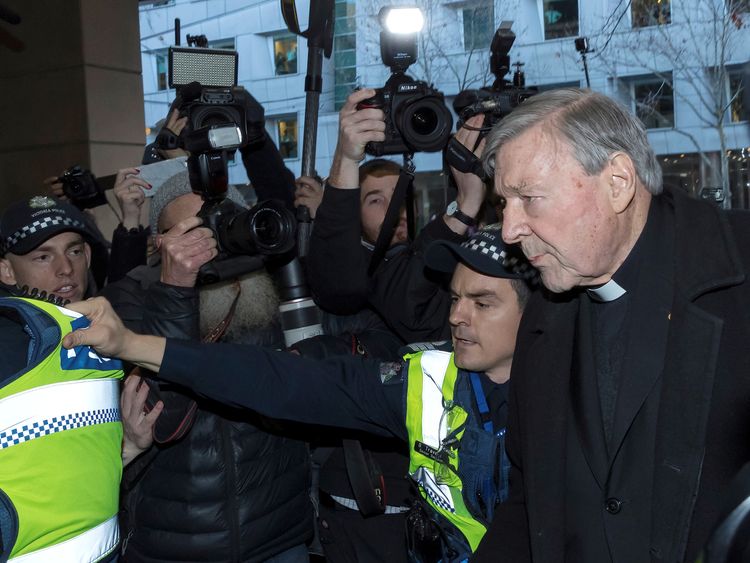 Vatican Treasurer Cardinal George Pell is surrounded by Australian police and members of the media as he arrives at the Melbourne Magistrates Court in Australia, July 26, 2017