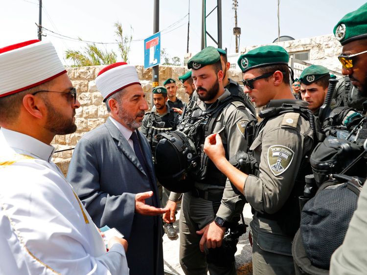 Palestinian Muslim clerics speak with Israeli border guards outside a main entrance to the al Aqsa mosque