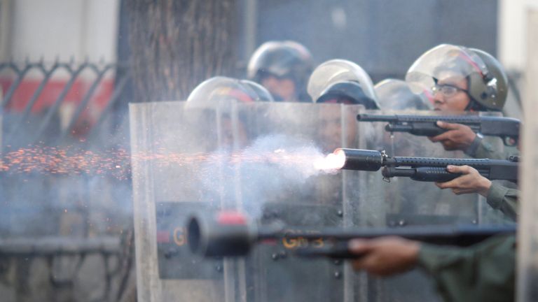 Riot security forces fire at a rally