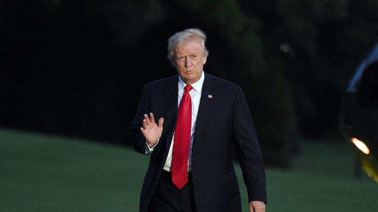 President Donald Trump waves as he returns to the White House 