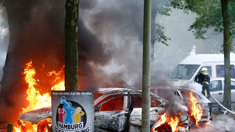 Firefighters work at the scene where a number of cars burnt down during the G20 summit in Hamburg, Germany
