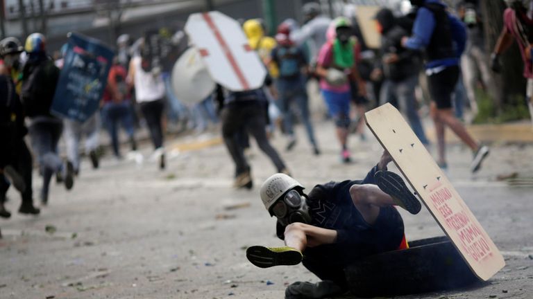 A demonstrator falls down while running away