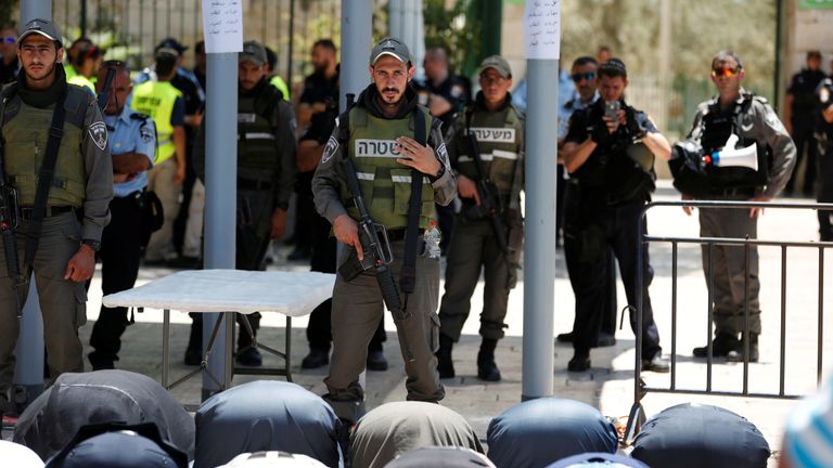 DATE IMPORTED:16 July, 2017Palestinians pray as Israeli police officers look on by newly installed metal detectors at an entrance to the compound known to Muslims as Noble Sanctuary and to Jews as Temple Mount in Jerusalem's Old City July 16, 2017. REUTERS/Ronen Zvulun