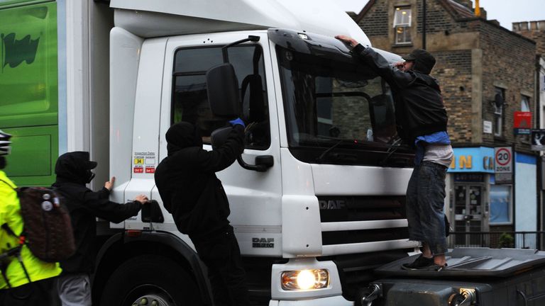 A lorry attempts to drive through makeshift road blocks at a protest in Kingsland Road in east London