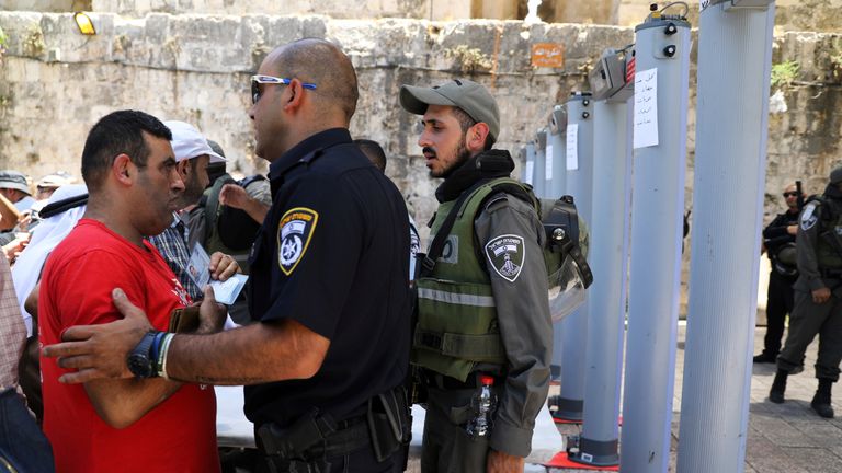 An Israeli police officer checks the identity of a Palestinian man next to newly installed metal detectors at an entrance to the compound known to Muslims as Noble Sanctuary and to Jews as Temple Mount, in Jerusalem's Old City July 16, 2017. REUTERS/Ammar Awad