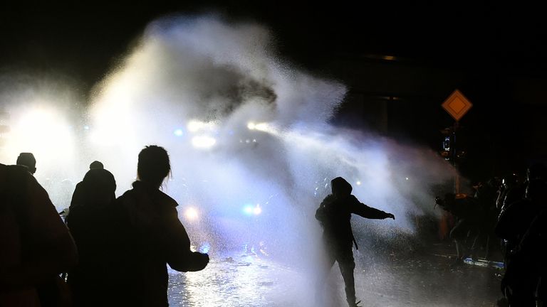 The police use water cannons during riots on July 8, 2017 in Hamburg, northern Germany, after the leaders of the world&#39;s top economies gathered for a G20 summit. German police and protestors had clashed already the day before at an anti-G20 march, with police using water cannon and tear gas to clear a hardcore of masked anti-capitalist demonstrators