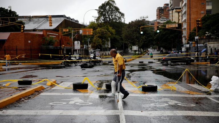 A pedestrian walks past a barricade 
