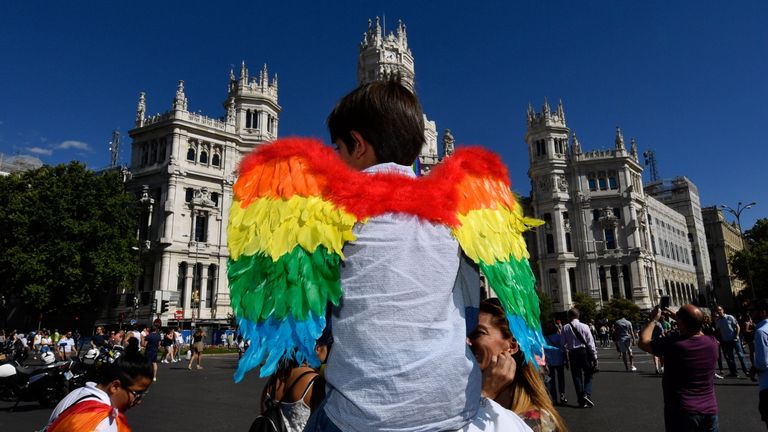 A child sporting rainbow wings in front of Madrid city hall