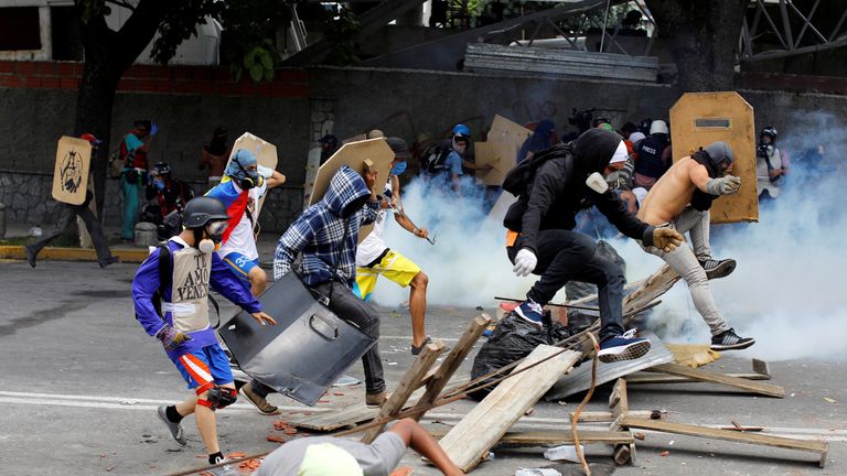 Demonstrators run away at a rally against Venezuelan President Nicolas Maduro's government in Caracas