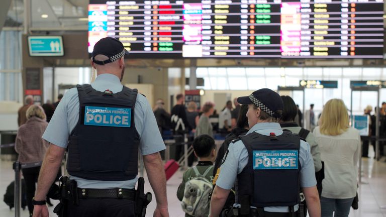 Australia Federal Police officers patrol the security lines at Sydney&#39;s Domestic Airport in Australia...
