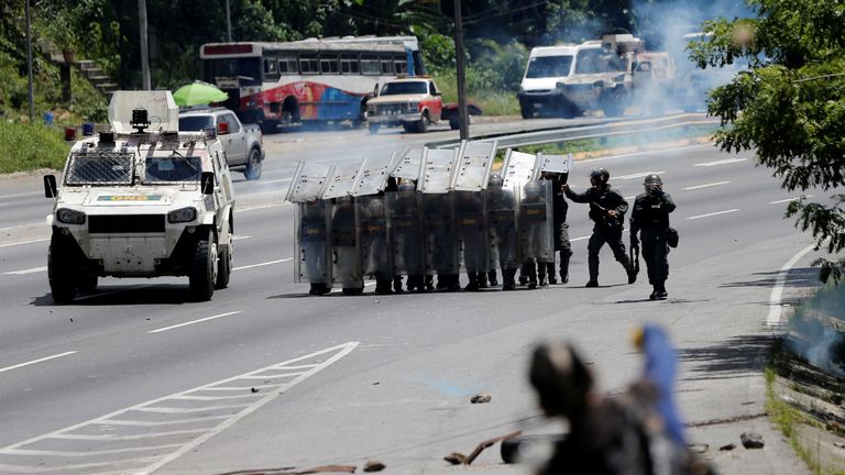 A demonstrator hurls rocks at security forces during clashes at a rally against Venezuelan President Nicolas Maduro's government in Caracas