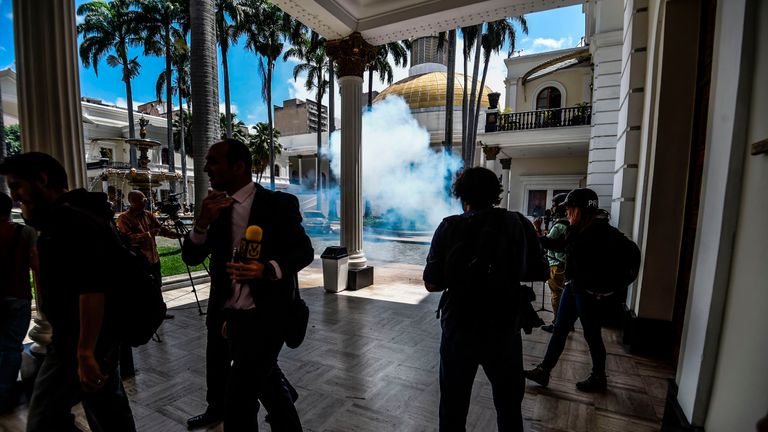 Journalists react as supporters of Venezuelan President Nicolas Maduro storm into the National Assembly building
