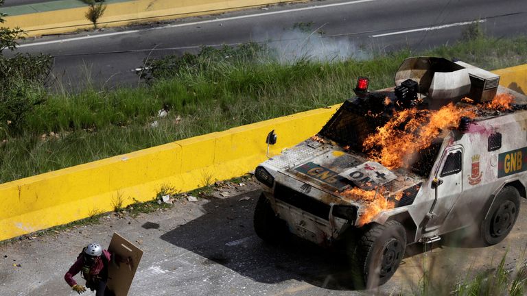 An armoured vehicle on fire during clashes with demonstrators