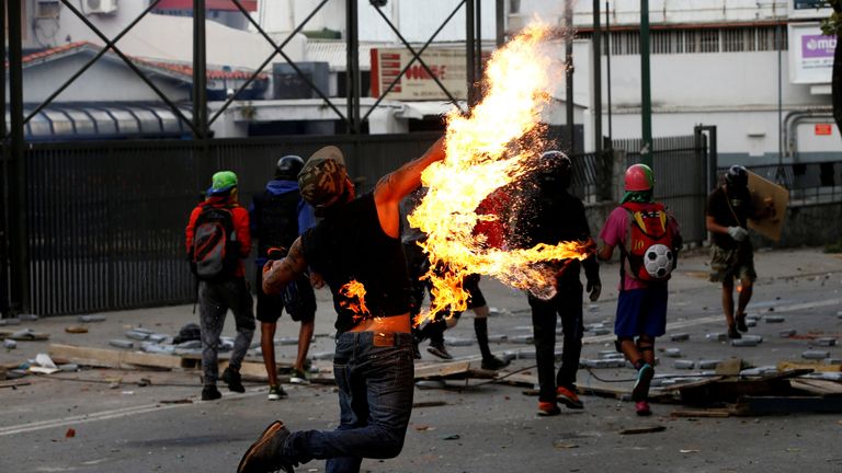 A demonstrator throws a petrol bomb 