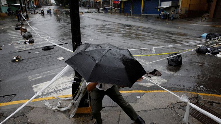 A pedestrian walks through a barricade 