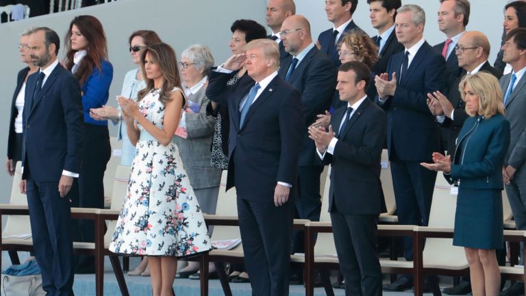 Donald Trump  salutes US troops, flanked by (from L) Melania Trump, French President Emmanuel Macron and his wife Brigitte