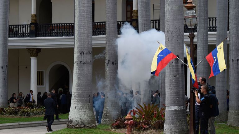 Employees of the National Assembly and members of the press run as Supporters of Venezuelan President Nicolas Maduro storm the building