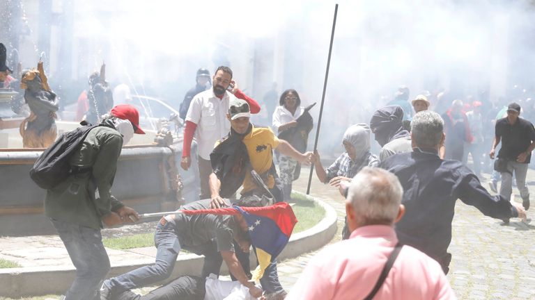 Government supporters attack a person outside Venezuela's opposition-controlled National Assembly