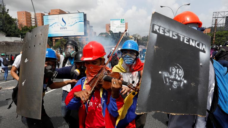 Wuilly Arteaga plays the violin during a protest against the poll