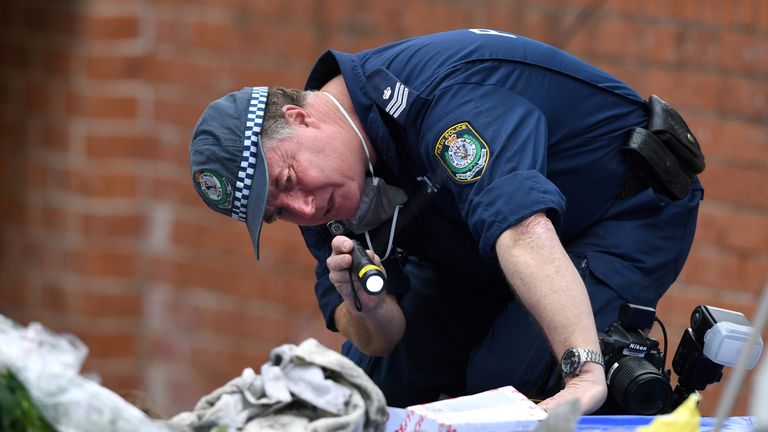 An Australian police officer searches items seized from a property during a raid in the Sydney suburb of Lakemba, Australia, July 31, 2017. AAP/Paul Miller/via REUTERS ATTENTION EDITORS - THIS PICTURE WAS PROVIDED BY A THIRD PARTY. NO RESALES. NO ARCHIVE. AUSTRALIA OUT. NEW ZEALAND OUT.