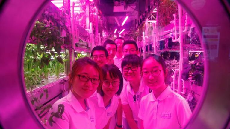 Volunteers smile from inside a simulated space cabin in which they temporarily live as a part of the scientistic Lunar Palace 365 Project, at Beihang University in Beijing, China July 9, 2017. REUTERS/Damir Sagolj