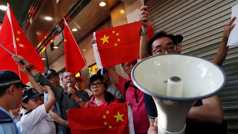 Pro-China supporters hold Chinese flags as they try to stop pro-democracy activists from protesting