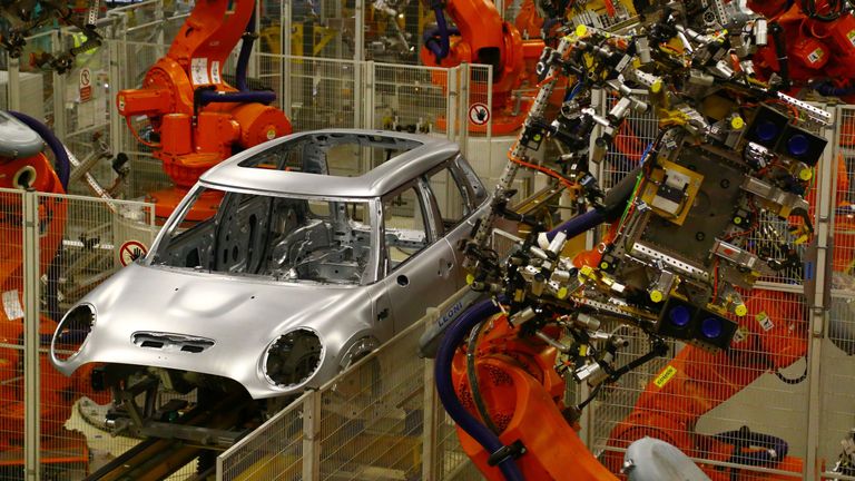 Minis in the &#39;Body in white&#39; stage of manufacture pass along a robotic assembly line at the BMW Mini car production plant in Oxford, west of London, on January 17, 2017