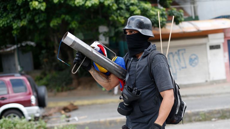 An armed member of the opposition blocks a road as Venezuelans go to the polls