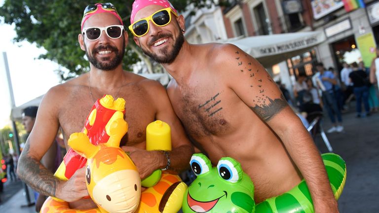 Two men in swimsuits pose during the WorldPride 2017 parade