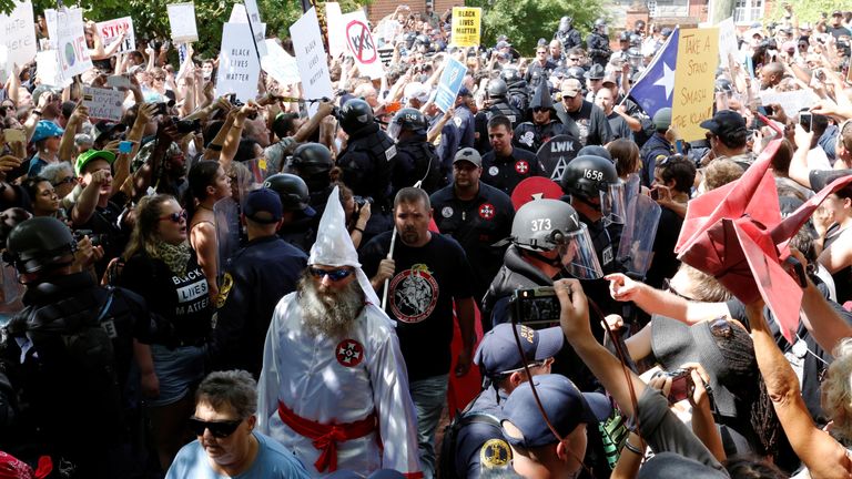 Riot police protect members of the Ku Klux Klan from counter-protesters as they arrive to rally in opposition to city proposals to remove or make changes to Confederate monuments in Charlottesville, Virginia
