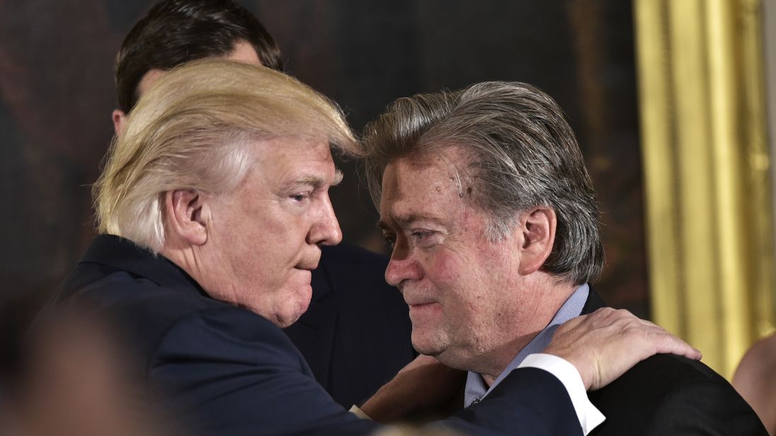 US President Donald Trump (L) congratulates Senior Counselor to the President Stephen Bannon during the swearing-in of senior staff in the East Room of the White House on January 22, 2017 in Washington, DC. / AFP / MANDEL NGAN (Photo credit should read MANDEL NGAN/AFP/Getty Images)