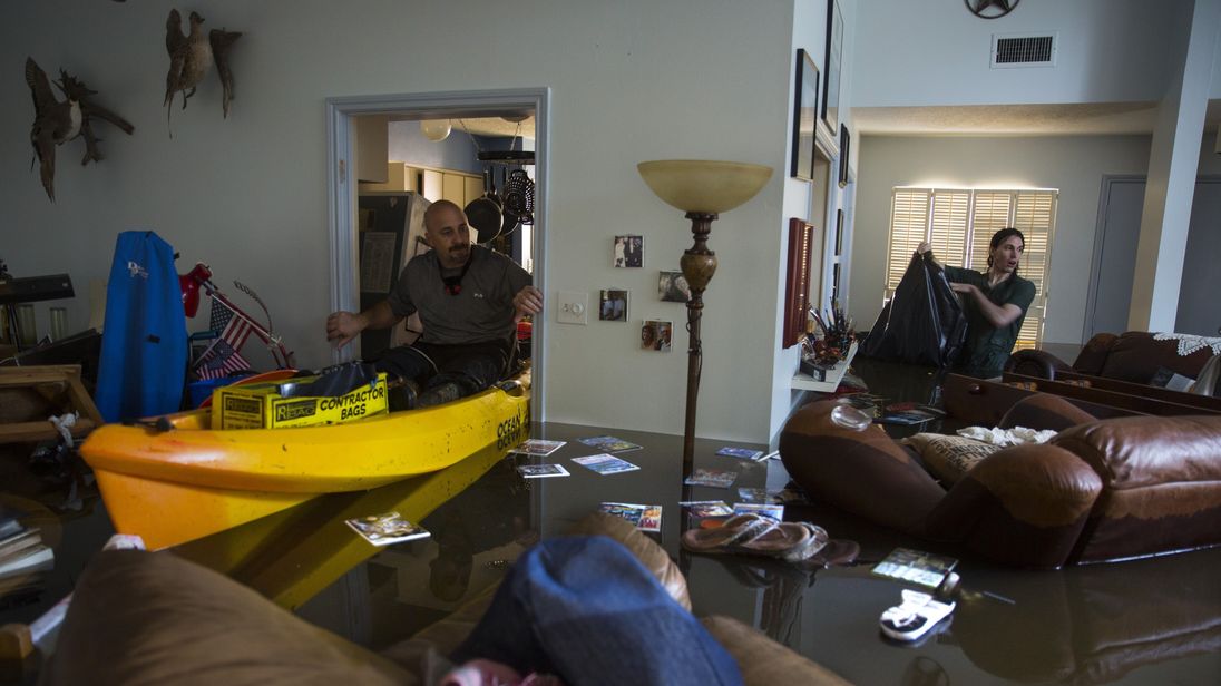 Larry Koser Jr. (L) searching his father&#39;s flooded house in west Houston with his son Matthew 
