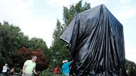 Workers replace the black tarp with which the City of Charlottesville covered the statue of Confederate General Robert E. Lee after John Miska (not shown) attempted to remove the covering in Charlottesville, Virginia, U.S., August 23, 2017