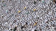 Muslim worshipers, some carrying umbrellas to protect them from the scorching sun, gather for prayer at Namirah mosque near Mount Arafat