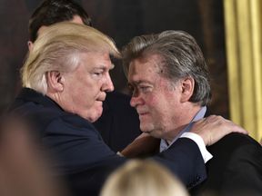 US President Donald Trump (L) congratulates Senior Counselor to the President Stephen Bannon during the swearing-in of senior staff in the East Room of the White House on January 22, 2017 in Washington, DC. / AFP / MANDEL NGAN (Photo credit should read MANDEL NGAN/AFP/Getty Images)