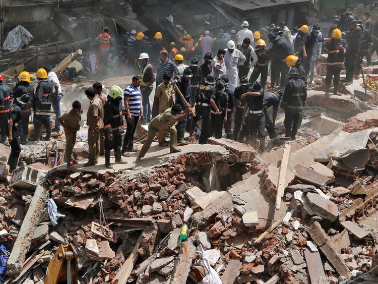 Firefighters and rescue workers search for survivors at the site of a collapsed building in Mumbai