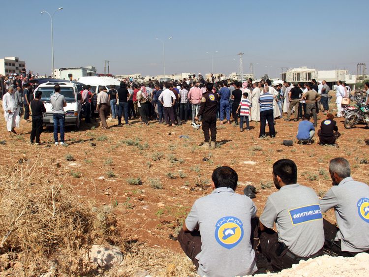 SCD volunteers watch as colleagues bury their fellow comrades during a funeral in Sarmin
