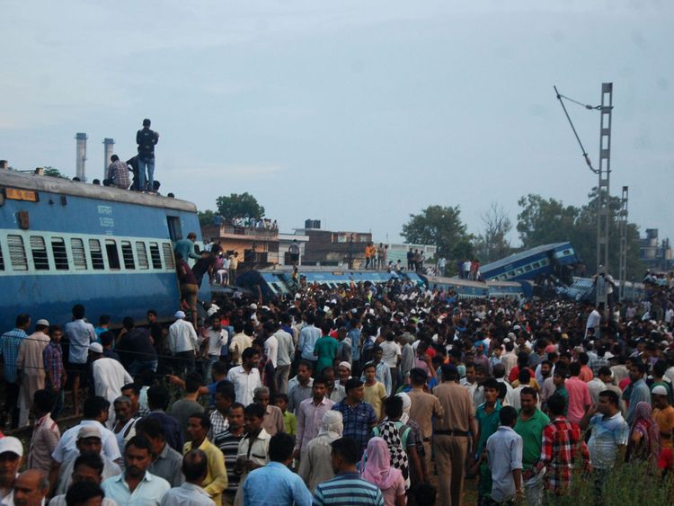 Local residents gather next to train carriages after an express train derailed near the town of Khatauli in the Indian state of Uttar Pradesh on August 19, 2017