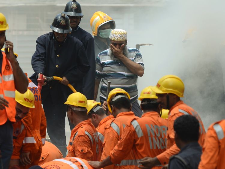 Rescue workers look for survivors at the site of a building collapse in Mumbai 