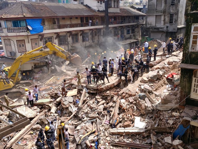 Firefighters and rescue workers search for survivors at the site of a collapsed building in Mumbai