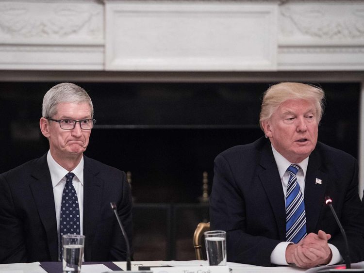 Apple CEO Tim Cook listens to US President Donald Trump during a tech summit  at the White House in June