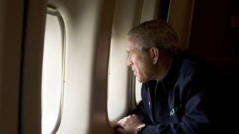 George W. Bush looks out over devastation from Hurricane Katrina - an event his slow response sparked outrage over