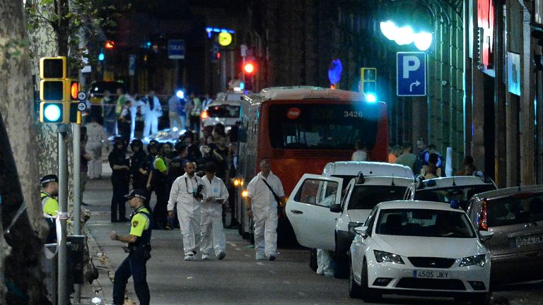 Forensic police arrive at a cordoned area after a van struck people in Barcelona